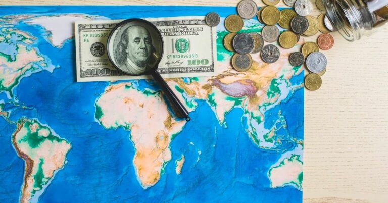 map of the world with money and magnifying glass